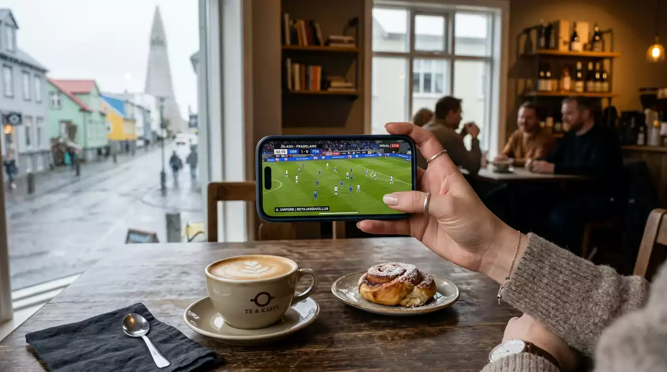 Farsími á borði á kaffihúsi í Reykjavík með fótboltaleik á skjánum og HM 2026